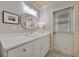 Bright bathroom with white cabinets and vanity and an oval mirror with recessed lighting at 880 N Shore Dr, Anna Maria, FL 34216