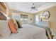 Bedroom featuring a comfortable bed, ceiling fan, and view into ensuite bathroom at 880 N Shore Dr, Anna Maria, FL 34216