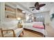 This bright bedroom has hardwood floors, two twin beds, and a decorative ceiling fan at 880 N Shore Dr, Anna Maria, FL 34216