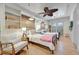 Light-filled bedroom with hardwood floors, two twin beds, wicker baskets, and a decorative ceiling fan at 880 N Shore Dr, Anna Maria, FL 34216