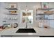 Bright kitchen with white subway tile, modern sink and stainless steel shelving at 880 N Shore Dr, Anna Maria, FL 34216