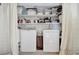 Convenient laundry area with stacked washer and dryer, shelving, and ample storage space at 880 N Shore Dr, Anna Maria, FL 34216