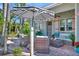 Charming patio area with wicker furniture, a striped umbrella, and tropical plants, creating a relaxing outdoor space at 880 N Shore Dr, Anna Maria, FL 34216