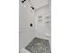 Modern shower featuring pebble flooring, white subway tile and a built-in niche at 880 N Shore Dr, Anna Maria, FL 34216