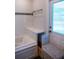 A bathroom area with a tub, cabinet with drawers, and a textured laundry basket at 1004 65Th W Ave, Bradenton, FL 34207
