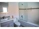 A clean bathroom with a tiled shower, vanity, toilet, and white walls at 1004 65Th W Ave, Bradenton, FL 34207