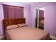 Cozy bedroom with wooden bed frame, mirrored closet doors, and purple walls at 1004 65Th W Ave, Bradenton, FL 34207