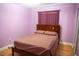 Cozy bedroom with wooden bed frame, purple walls, and a window with matching curtains at 1004 65Th W Ave, Bradenton, FL 34207