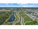 Expansive aerial view showcasing a community with a lake, walking paths, green spaces, and residential homes at 10120 Canaveral Cir, Sarasota, FL 34241