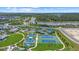 Aerial view of tennis courts, a lake with a fountain, and lush landscaping in a vibrant community at 10120 Canaveral Cir, Sarasota, FL 34241