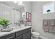 Modern bathroom featuring a single vanity with gray cabinets, stylish decor, and a bright, clean ambiance at 10120 Canaveral Cir, Sarasota, FL 34241