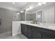 Modern bathroom featuring a double sink vanity, white countertop, and gray tiled shower at 10120 Canaveral Cir, Sarasota, FL 34241