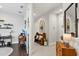 Welcoming hallway featuring stylish decor, tile flooring, and smooth transitions to adjacent living spaces and a study area at 10120 Canaveral Cir, Sarasota, FL 34241