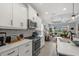 Beautiful, open kitchen with white cabinetry, stainless appliances, and a view into the adjacent living room at 10120 Canaveral Cir, Sarasota, FL 34241
