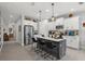 Bright kitchen features stainless appliances, white cabinets, gray island with quartz countertop, and pendant lighting at 10120 Canaveral Cir, Sarasota, FL 34241