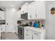 Bright kitchen with stainless steel appliances, white cabinets, quartz countertops, and sleek black hardware at 10120 Canaveral Cir, Sarasota, FL 34241