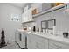 Well-organized laundry room featuring modern appliances, ample counter space, and stylish wallpaper and decor at 10120 Canaveral Cir, Sarasota, FL 34241