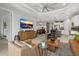 Open-concept living room showcasing stylish furnishings, a modern TV, and seamless transition to the dining and kitchen areas at 10120 Canaveral Cir, Sarasota, FL 34241