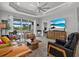 Comfortable living room features tile flooring, tray ceiling, ceiling fan, and a view of the pool at 10120 Canaveral Cir, Sarasota, FL 34241