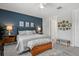 Comfortable main bedroom with a blue accent wall, ceiling fan, area rug, and furniture at 10120 Canaveral Cir, Sarasota, FL 34241
