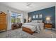 Comfortable main bedroom with a blue accent wall, ceiling fan, area rug, and furniture at 10120 Canaveral Cir, Sarasota, FL 34241