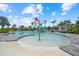 Community pool with colorful splash features and clear blue water, surrounded by palm trees at 10120 Canaveral Cir, Sarasota, FL 34241