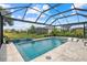 Screened-in pool with a waterfall feature and a landscaped yard with comfortable tanning chairs at 10120 Canaveral Cir, Sarasota, FL 34241