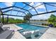 Screened-in pool with tanning ledge, a beautiful backyard and lake view from tanning chairs at 10120 Canaveral Cir, Sarasota, FL 34241