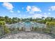 Beautiful pool area surrounded by lush landscaping and comfortable lounge chairs under the blue sky at 10120 Canaveral Cir, Sarasota, FL 34241