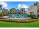 Grand Park entrance sign with water feature and colorful landscaping against a backdrop of palm trees and blue sky at 10120 Canaveral Cir, Sarasota, FL 34241