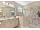 Elegant bathroom with neutral finishes, a glass shower, and bright vanity lighting at 10186 Crystal Isle Cir, Sarasota, FL 34241