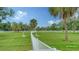 Expansive fenced community dog park featuring green grass and shade trees for pets to enjoy at 10186 Crystal Isle Cir, Sarasota, FL 34241