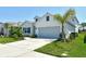 This home has a two-car garage, neutral color palette, green grass and low-maintenance landscaping at 10186 Crystal Isle Cir, Sarasota, FL 34241