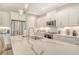 Modern kitchen featuring white cabinets, stainless steel appliances, a large island with quartz countertops, and designer lighting at 10186 Crystal Isle Cir, Sarasota, FL 34241