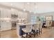 Modern kitchen features white cabinets, stainless steel appliances, a large center island, and an open connection to the dining area at 10186 Crystal Isle Cir, Sarasota, FL 34241