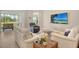 Relaxing living room featuring neutral walls, hardwood floors, comfortable seating, and access to a screened in lanai at 10186 Crystal Isle Cir, Sarasota, FL 34241