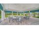 A covered outdoor seating area with tables and chairs overlooks community green space at 10186 Crystal Isle Cir, Sarasota, FL 34241