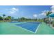 Enjoy a match on the community's blue and green tennis courts, surrounded by lush landscaping and a covered seating area at 10186 Crystal Isle Cir, Sarasota, FL 34241