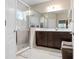 Bathroom featuring a large glass shower, dual sinks, and stylish dark wood cabinets at 11435 Fort Lauderdale Pl, Venice, FL 34293