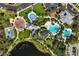 Aerial view showcasing a playground, splash pad, pool, and clubhouse, all nestled by a lake at 11435 Fort Lauderdale Pl, Venice, FL 34293