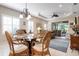 Open-concept living features dining area with modern chandelier, leading to living room at 11435 Fort Lauderdale Pl, Venice, FL 34293