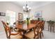 Elegant dining room with a wood table, chandelier, and large windows offering natural light at 11435 Fort Lauderdale Pl, Venice, FL 34293