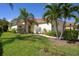 Charming home features a tile roof, well-manicured lawn, and lush tropical landscaping at 11435 Fort Lauderdale Pl, Venice, FL 34293