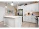 Bright kitchen boasts stainless steel appliances, white cabinetry, and a large island with sink at 11435 Fort Lauderdale Pl, Venice, FL 34293