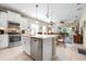 Open kitchen view showcasing the island, stainless steel appliances, and seamless flow to living spaces at 11435 Fort Lauderdale Pl, Venice, FL 34293