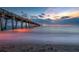A long pier stretches into the water at sunset with colorful light reflecting on the water and sand at 11435 Fort Lauderdale Pl, Venice, FL 34293