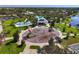 Aerial view of community playground with splash pad, picnic pavilion, and lush green space by a lake at 11435 Fort Lauderdale Pl, Venice, FL 34293