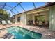 Relaxing lanai with a grill and dining near the screened-in pool at 11435 Fort Lauderdale Pl, Venice, FL 34293