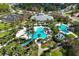 Aerial view of a lavish community pool area featuring a waterslide, tiki bar, and meticulously landscaped grounds at 11435 Fort Lauderdale Pl, Venice, FL 34293