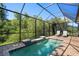 Relaxing screened-in pool area with a water feature and comfortable lounge chairs at 11435 Fort Lauderdale Pl, Venice, FL 34293